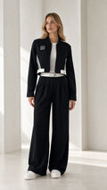Full front view of model wearing black cropped bomber jacket and wide-leg trousers set