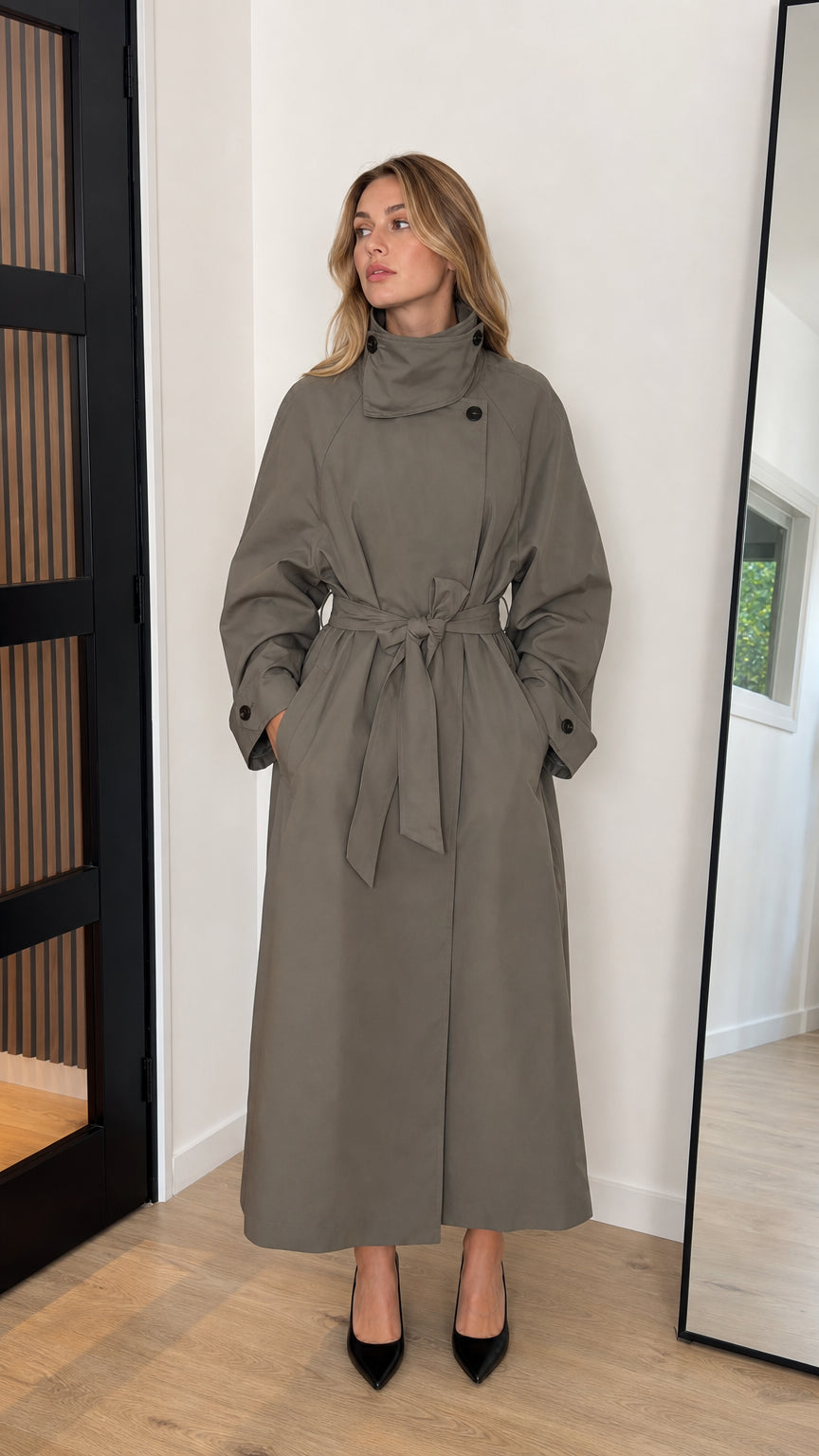 Front view of woman wearing an olive green high neck belted maxi trench coat