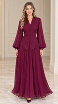 Front full-length view of woman wearing burgundy pleated maxi evening dress with bishop sleeves