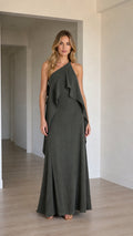 Full front view of a model wearing a charcoal grey one-shoulder cascading ruffle maxi dress