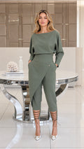 Front view of woman wearing sage green batwing top and asymmetrical wrap pants two-piece set