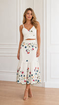 Front view of model wearing white floral embroidered crop top and tiered midi skirt set