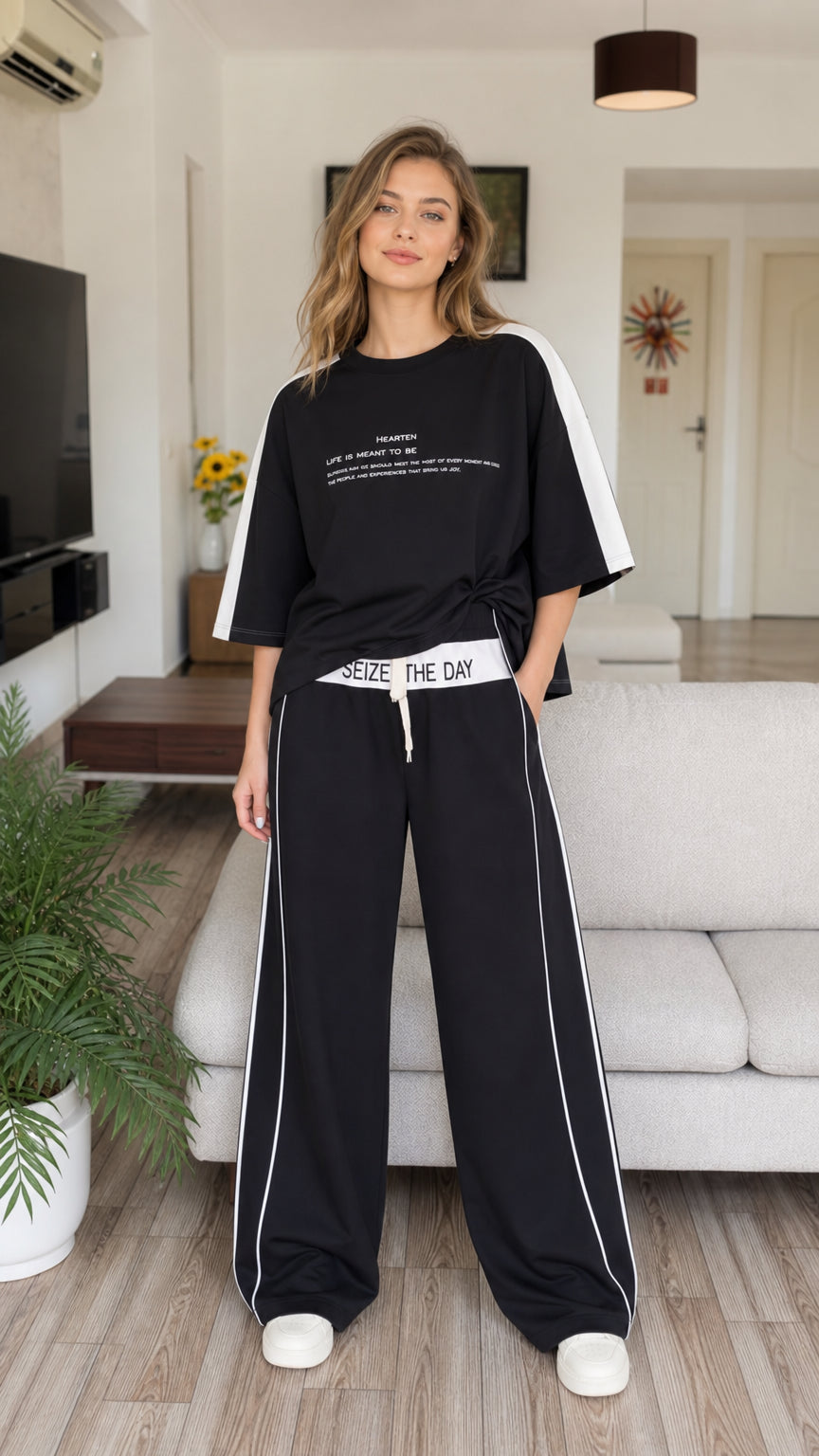 Full front view of model wearing black two-piece t-shirt and wide-leg pant lounge set