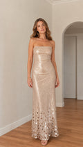 Front view of model wearing champagne strapless sequin column maxi dress