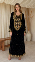Model wearing black embroidered velvet maxi kaftan dress with gold beadwork - front view