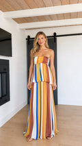 Front view of model wearing Mustard Multi strapless striped tiered maxi dress