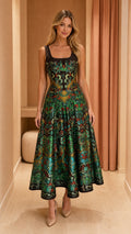 Front view of woman wearing emerald green jacquard square neck A-line midi dress with beige pumps