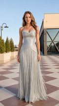 Front view of model wearing a strapless silver fringe maxi evening gown on an outdoor terrace