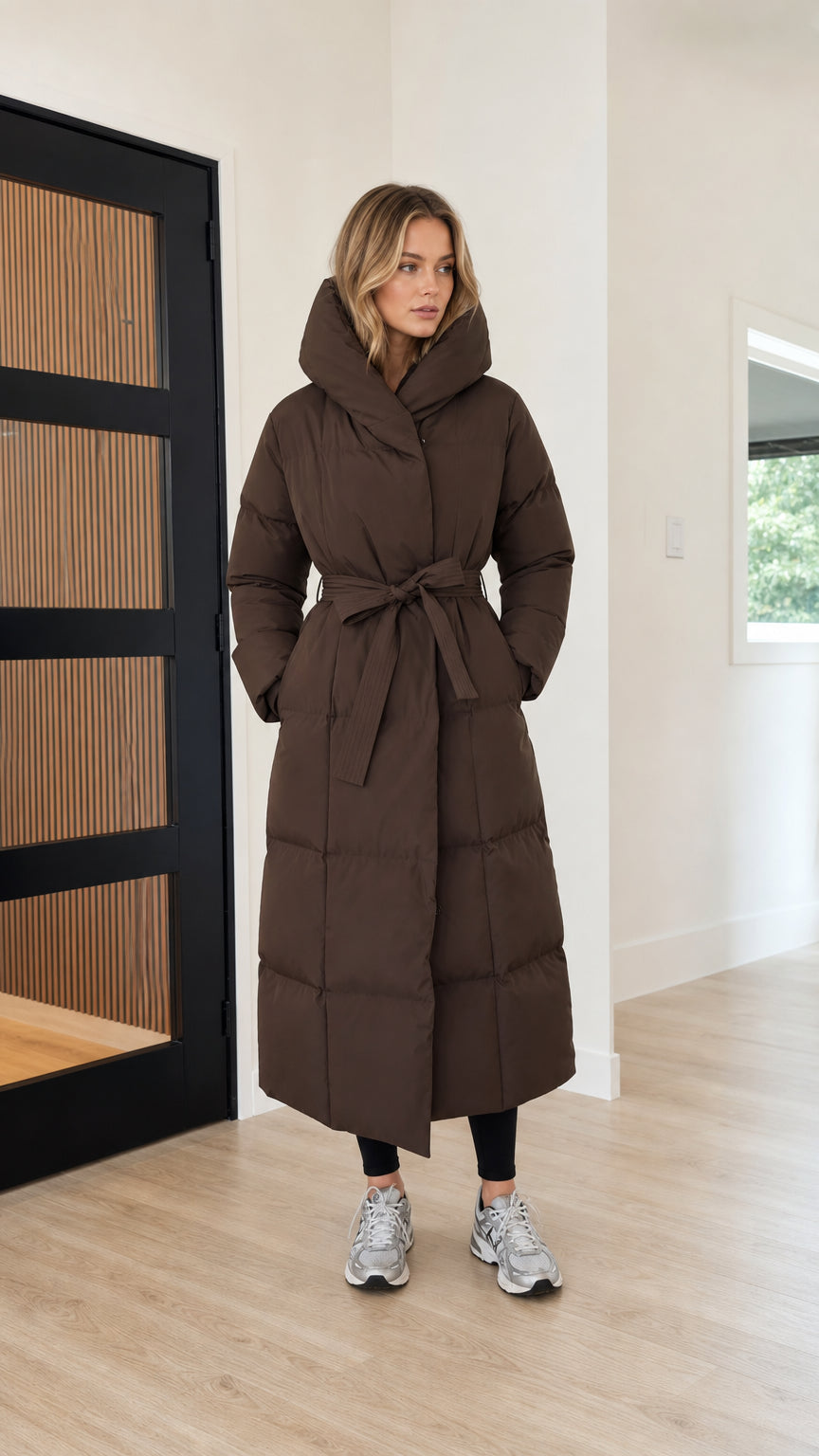 Front full view of women's long belted maxi puffer coat in chocolate brown