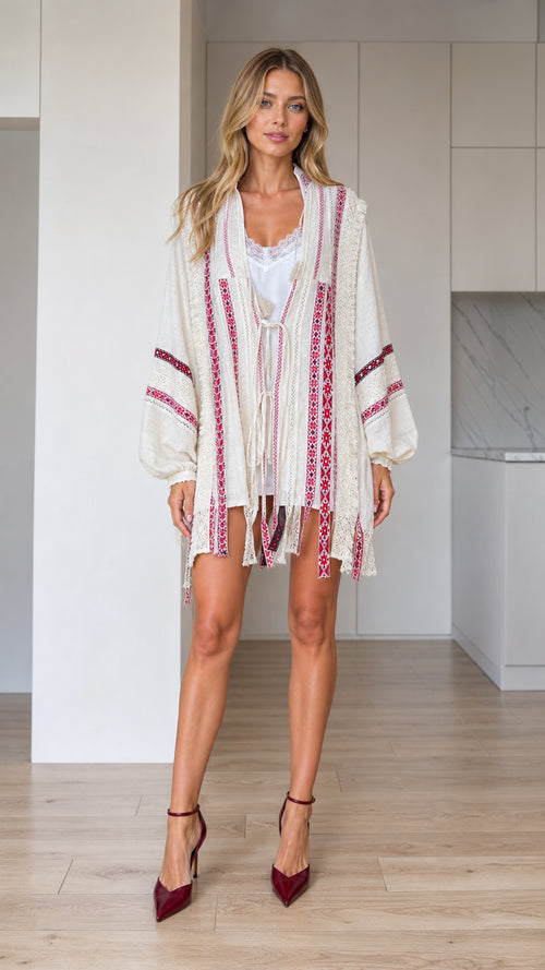 Front view of woman wearing ivory boho embroidered tassel open-front kimono cardigan