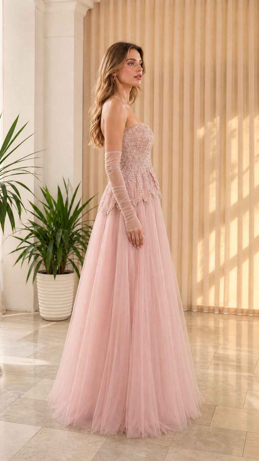 Side-front view of dusty pink strapless tulle formal dress with beaded corset top