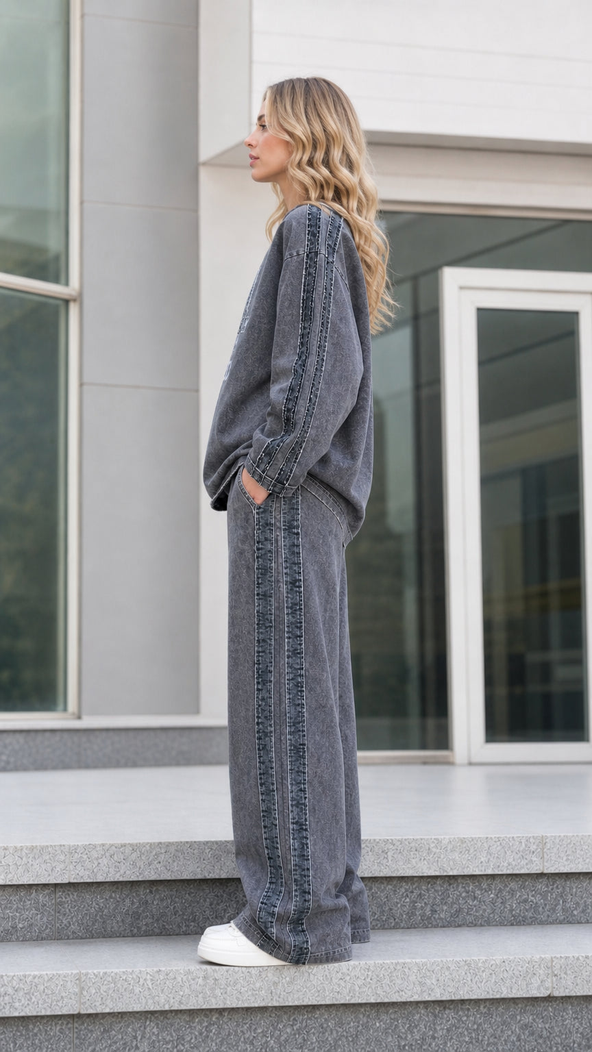 Side profile view of charcoal grey oversized sweatshirt and wide leg track pants showing side trim