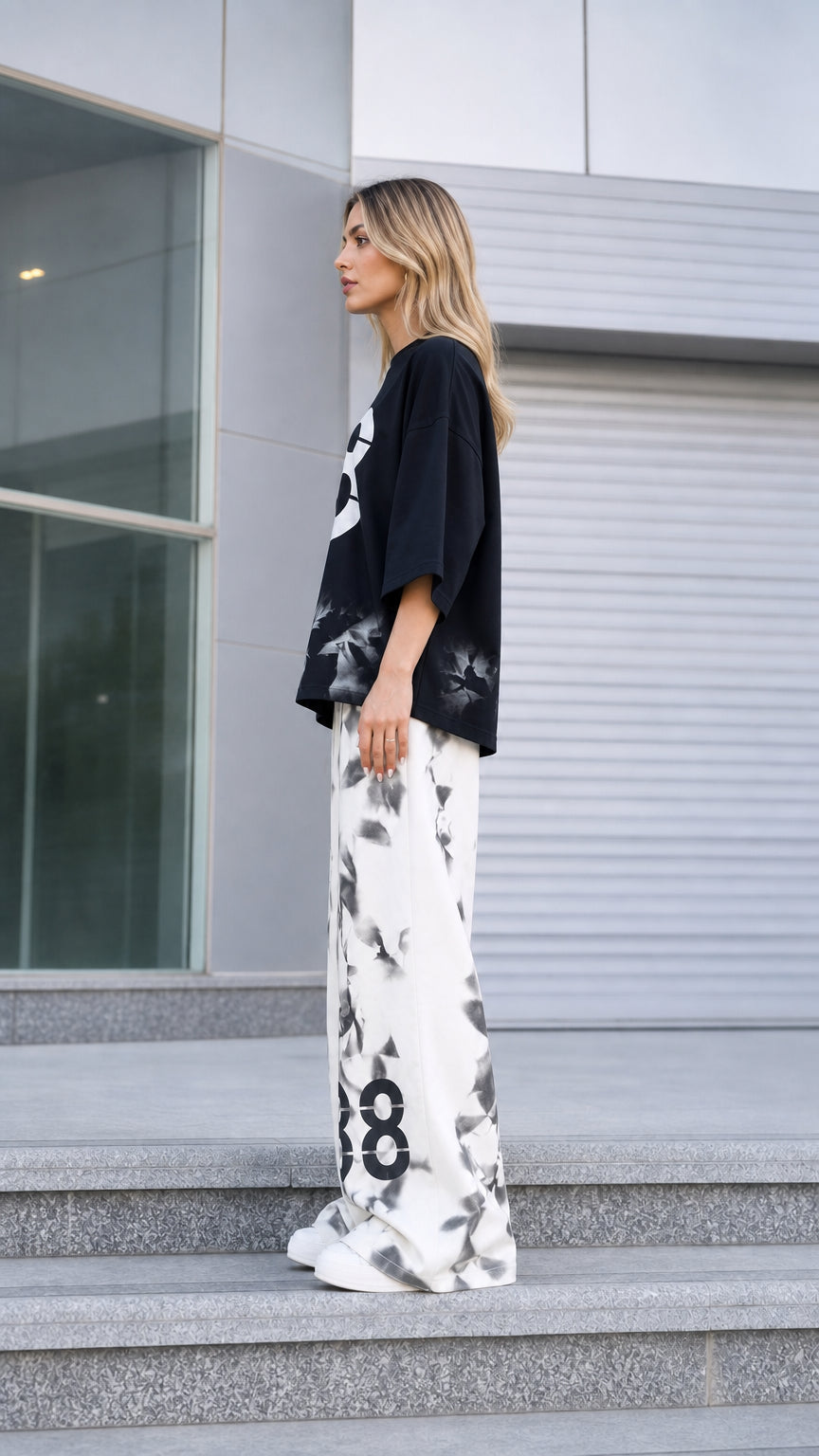 Side profile of woman wearing black graphic streetwear two-piece co-ord set