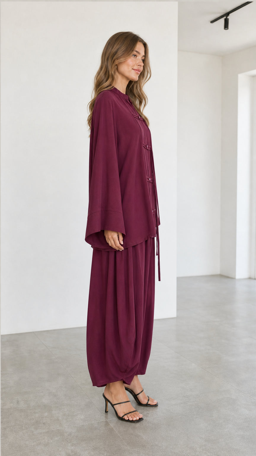 Side profile of women wearing burgundy two-piece tunic and harem pant set