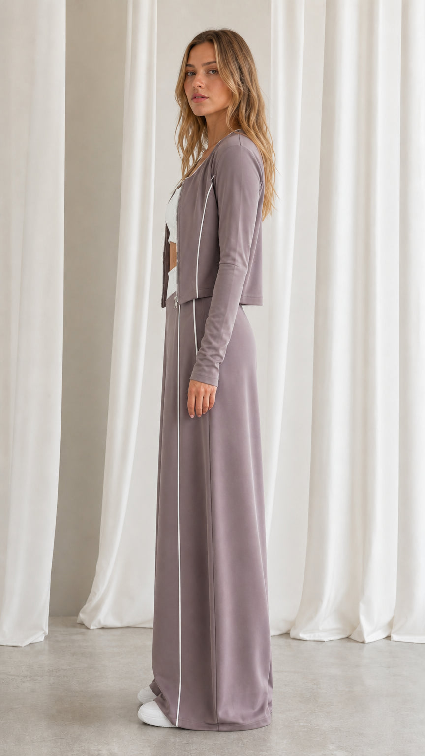 Side profile view of women's dusty mauve cropped zip jacket and wide-leg track pants set