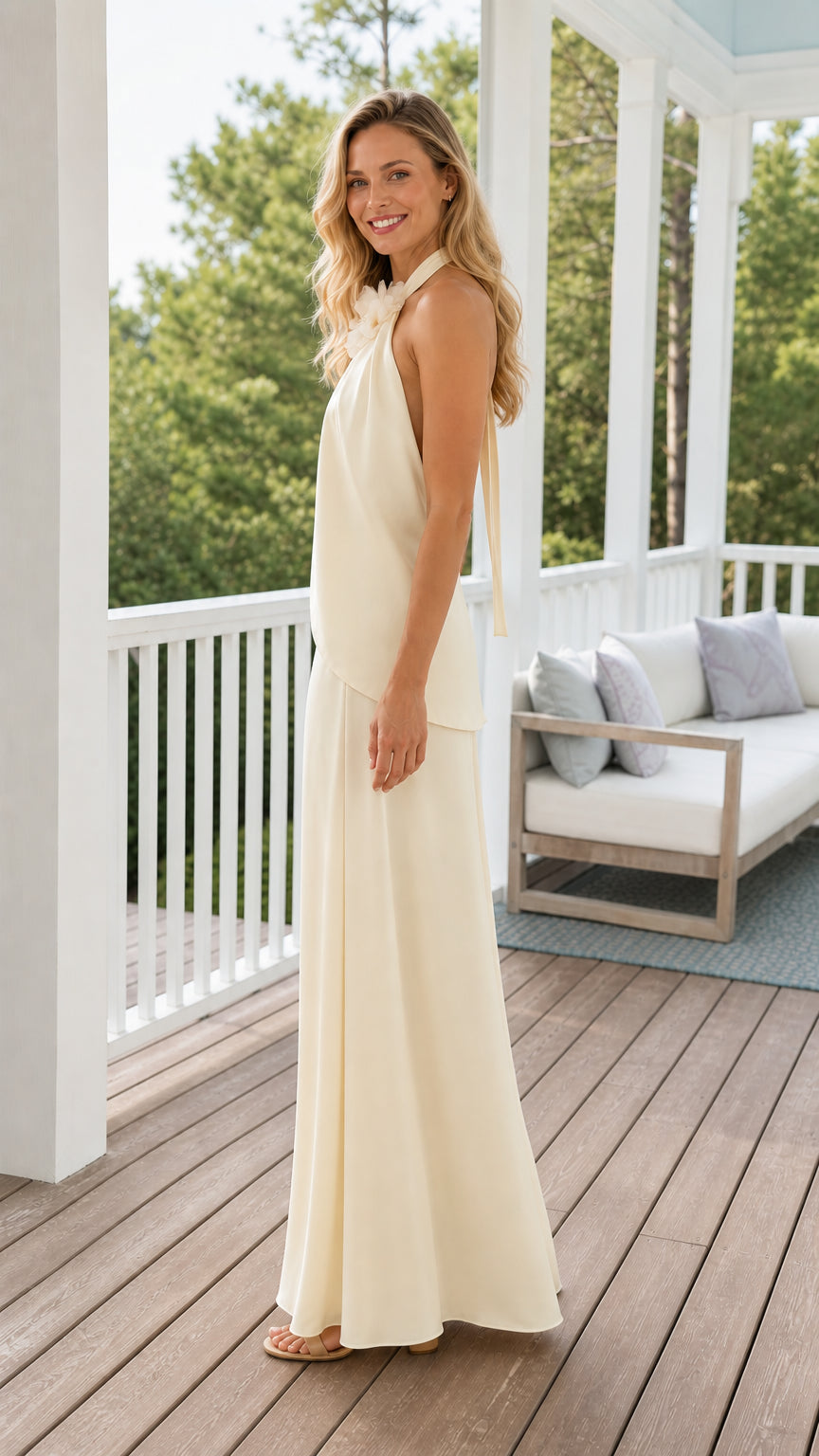 Side angle of model wearing cream halter maxi set on balcony
