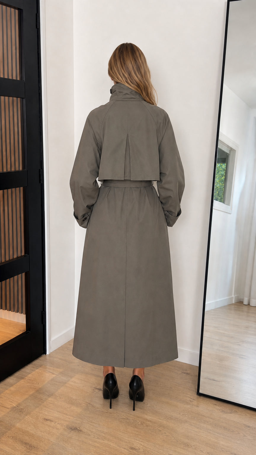 Back view of olive green maxi trench coat featuring storm flap and full length cut