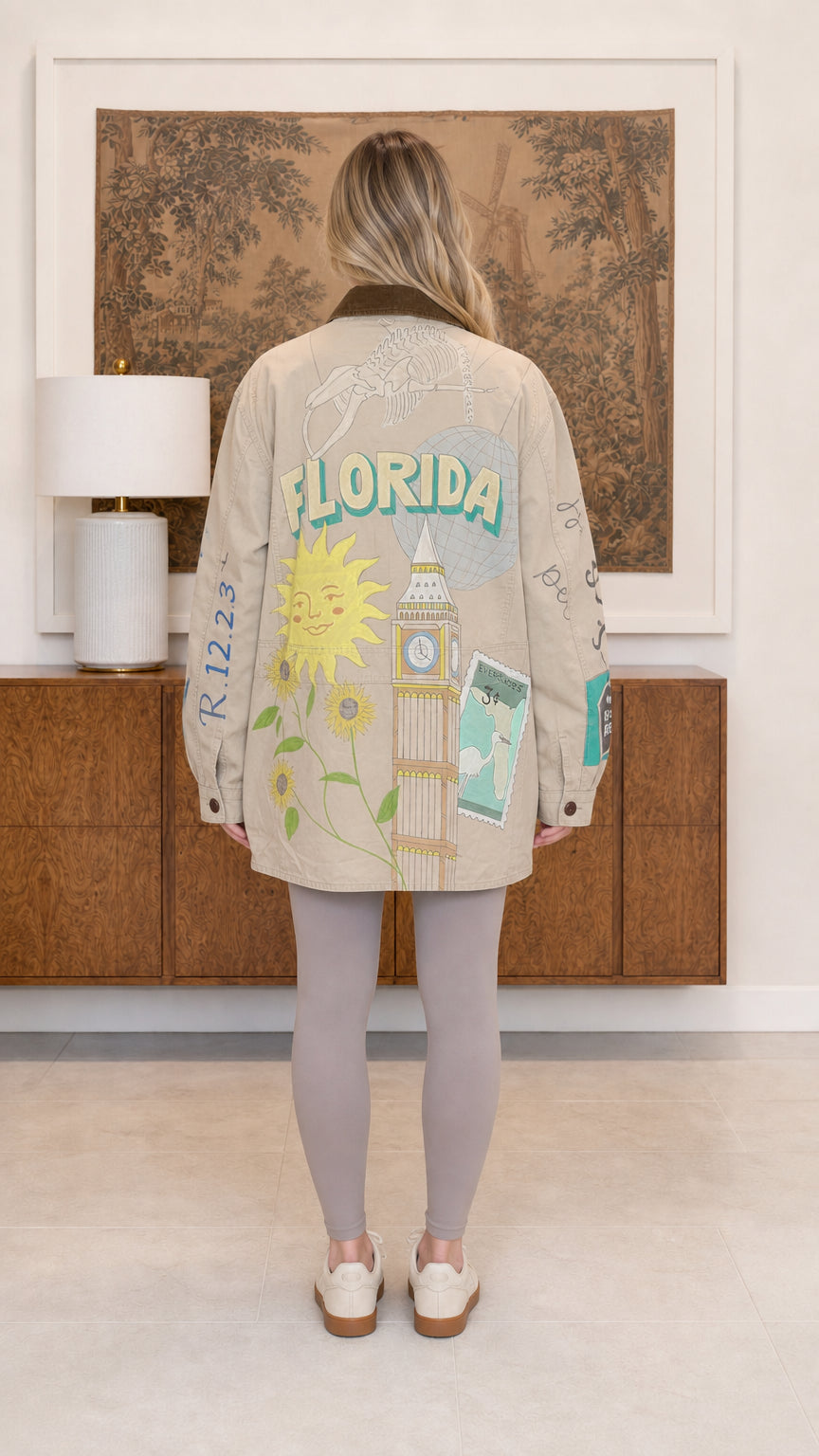 Back view of beige barn jacket showing colorful Florida travel graphic illustrations