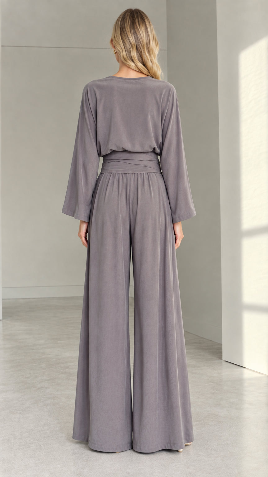 Back view of woman in a slate grey long-sleeve wide-leg jumpsuit