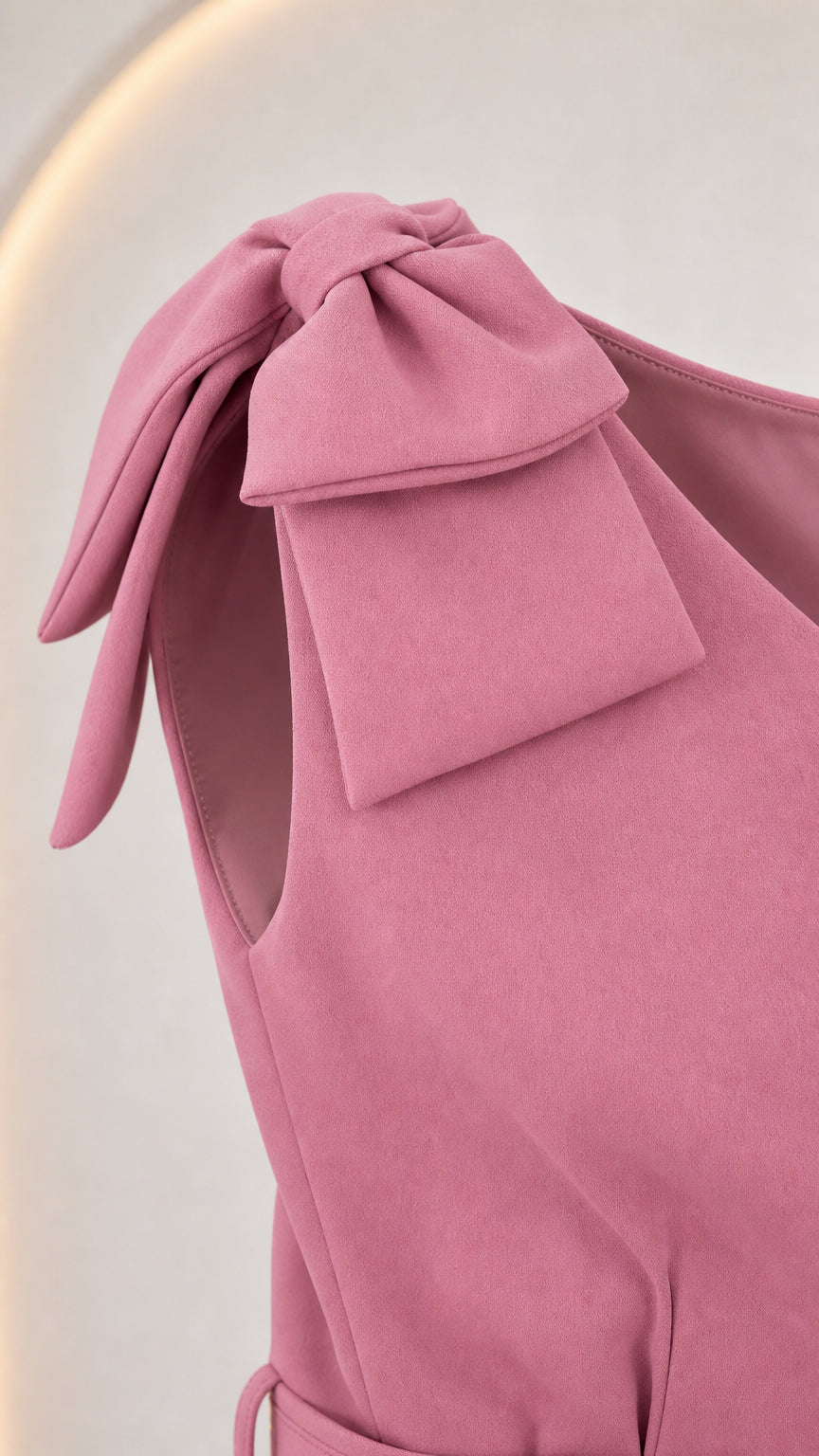 Close-up detail of the shoulder bow on the pink dress