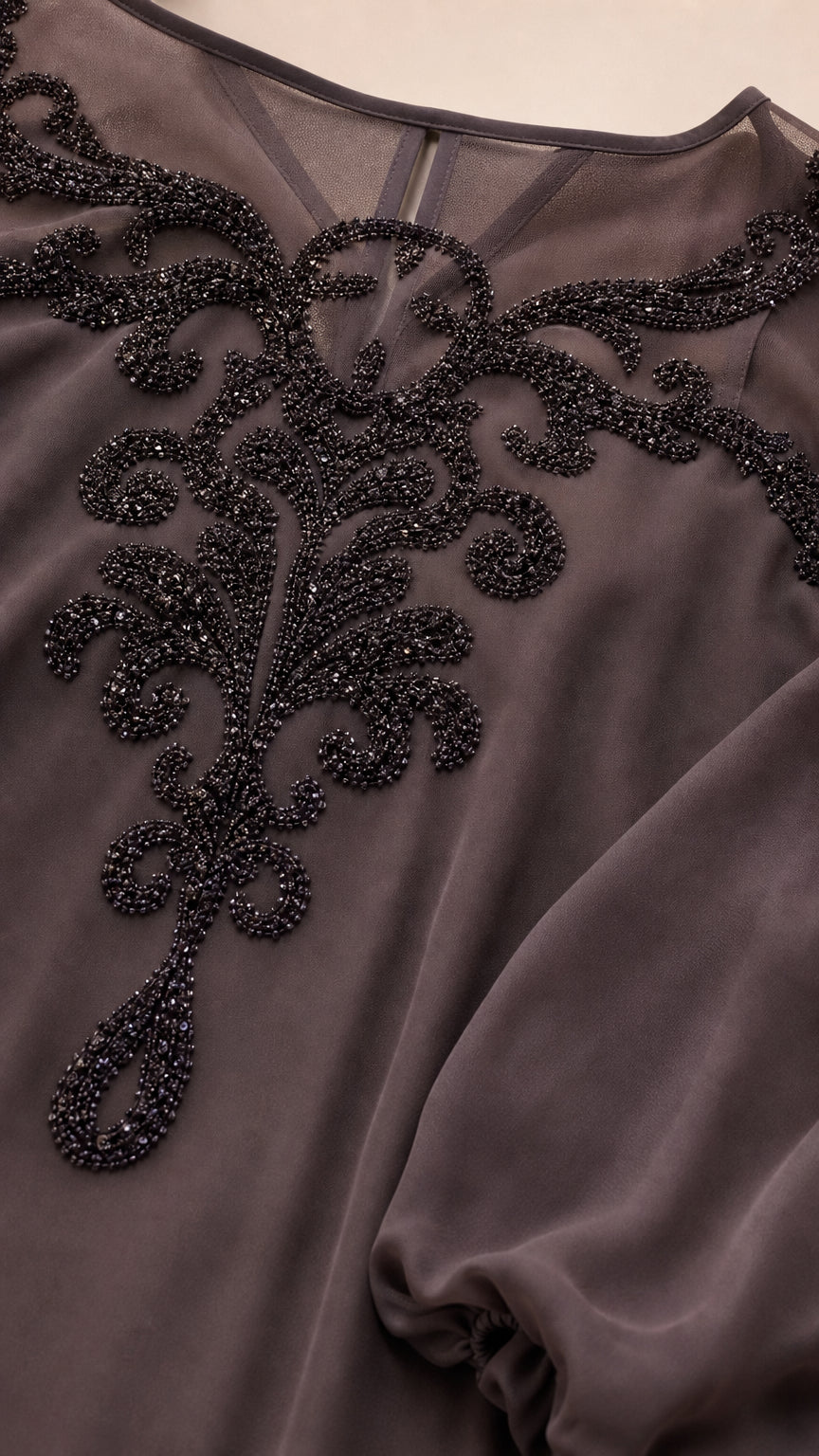 Close-up detail of sheer illusion neckline with intricate black beadwork