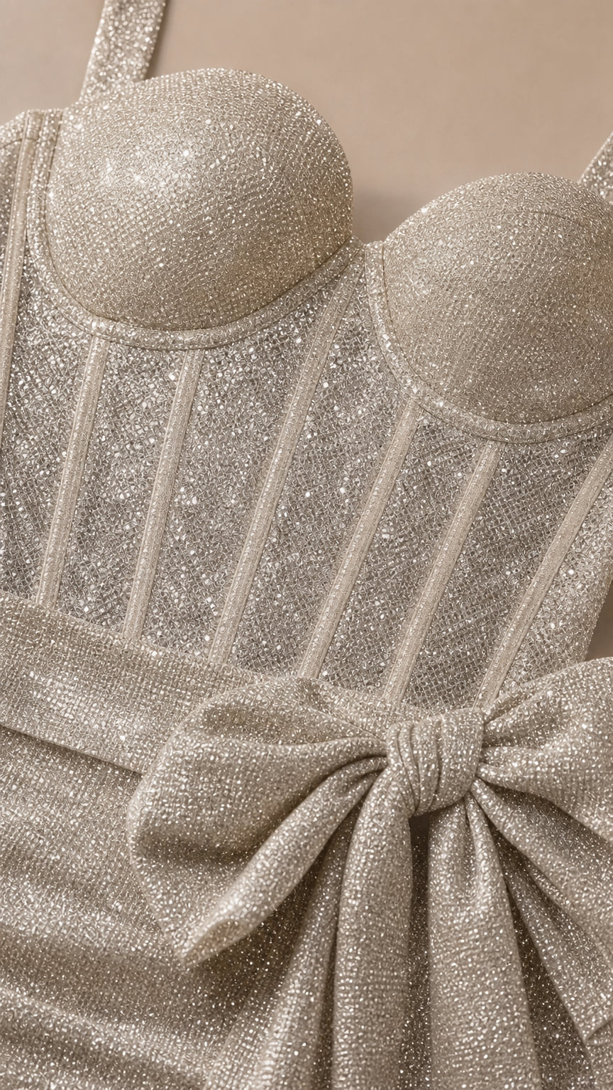Close-up of textured glitter fabric, structured corset bodice, and side bow detail