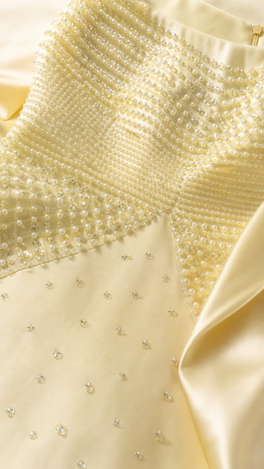Close-up detail of textured pearl beadwork and embellishments on gown bodice