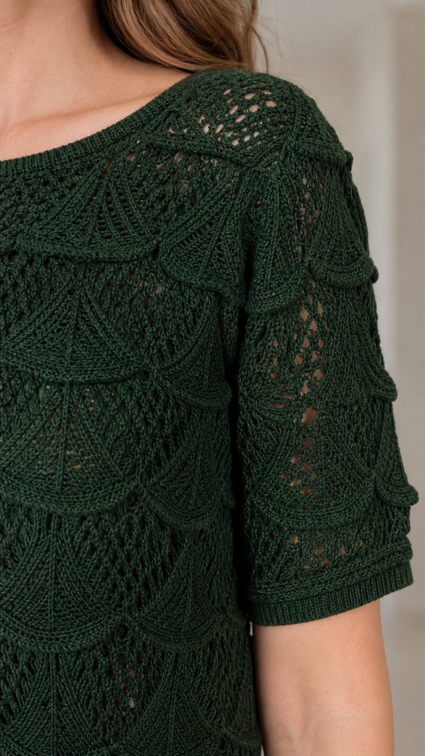 Close-up of shoulder and sleeve detail on dark green knit dress