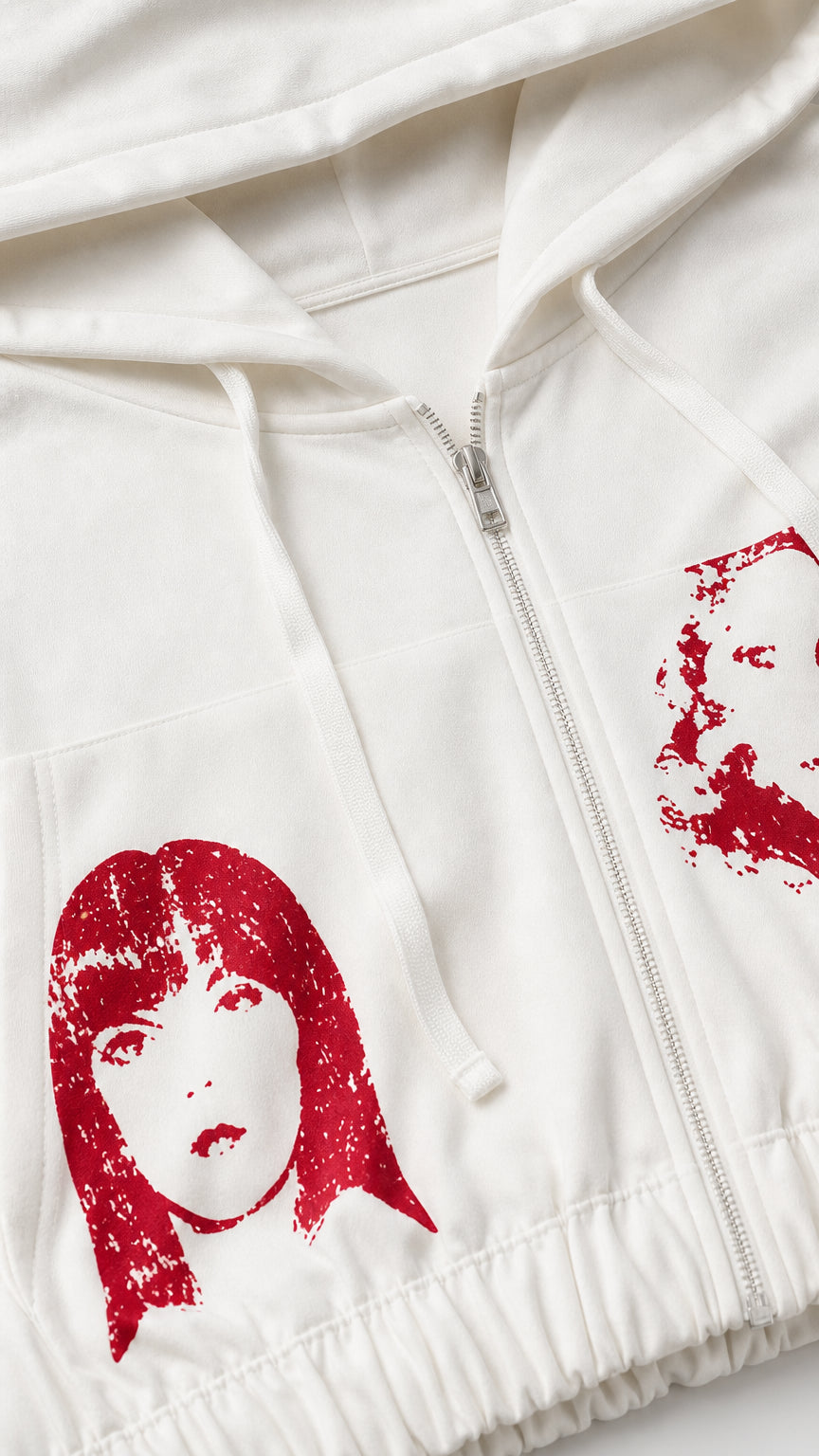 Close-up detail of white zip-up hoodie showing red graphic print, zipper, and fabric texture