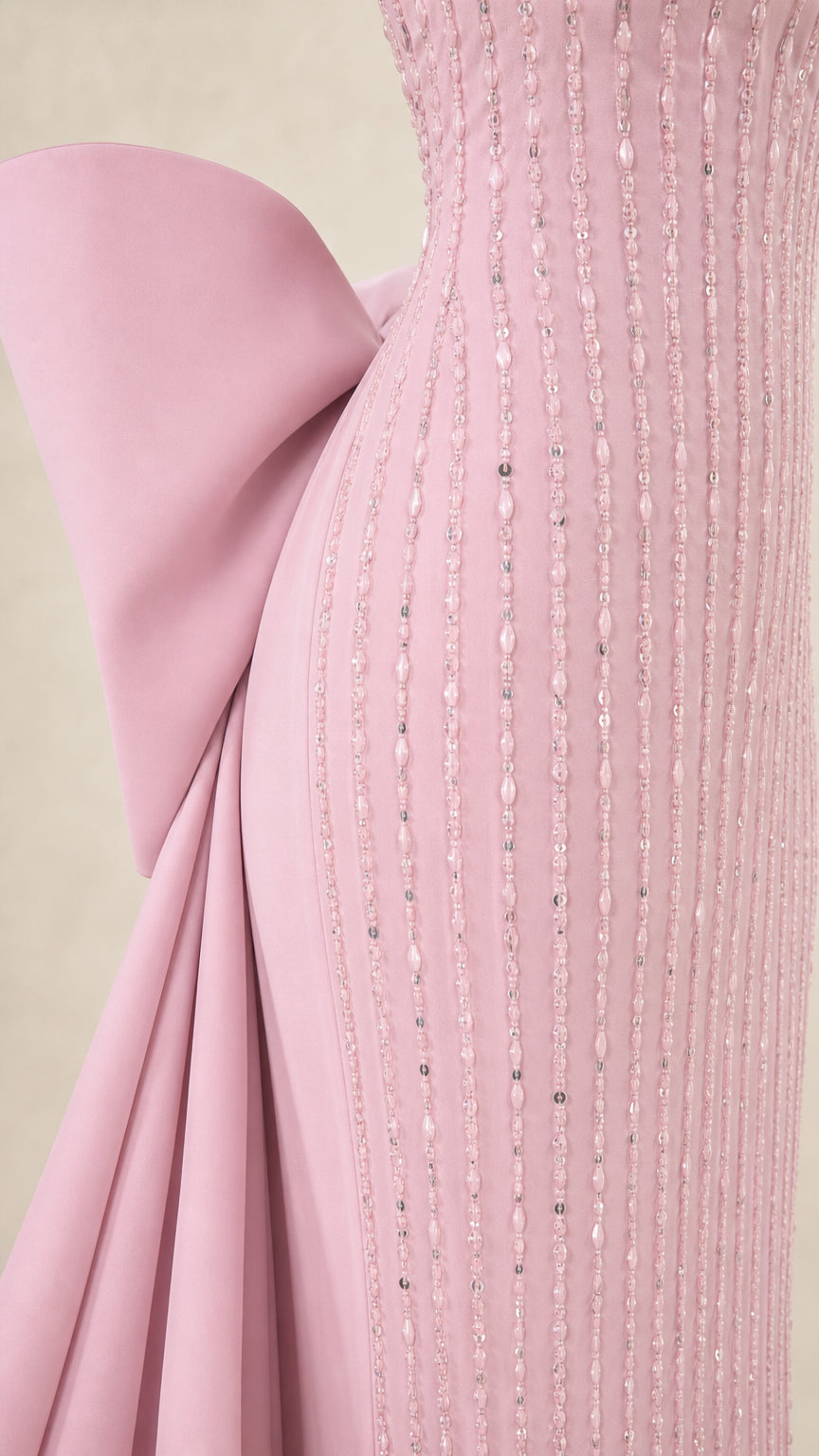 Close-up detail of linear beading and structured bow on blush pink gown