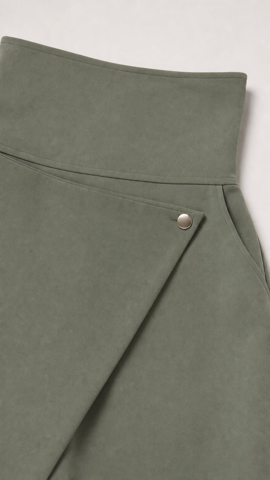 Close-up detail of high-waist asymmetrical wrap front with metallic snap button